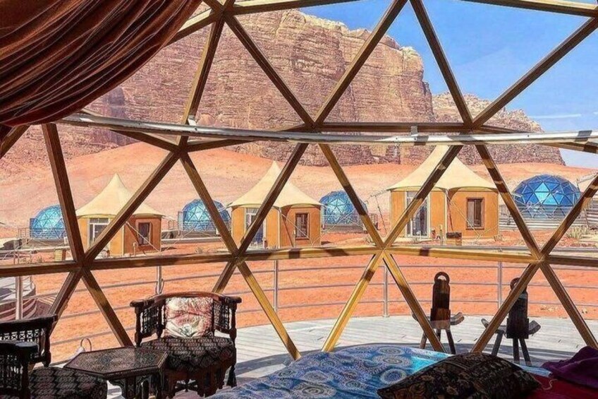 A geodesic dome structure with a desert landscape in the background. 5