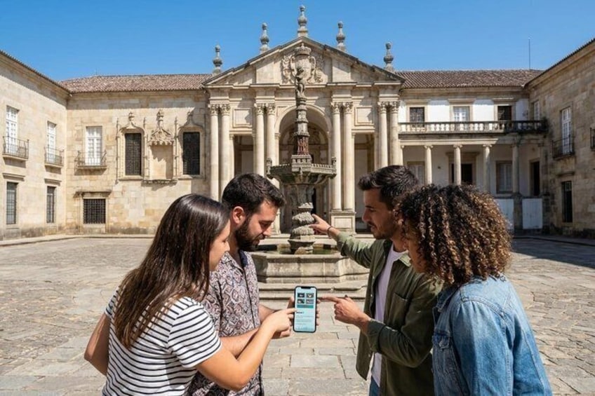 Un groupe de personnes se tient devant un bâtiment historique, près d’une fontaine. 5