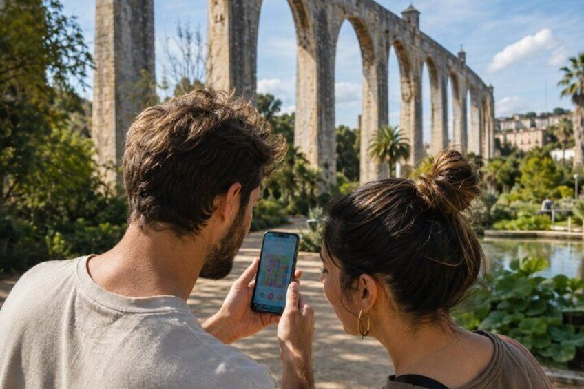 Een koppel maakt een foto met een smartphone voor een stenen brug met bogen. 5