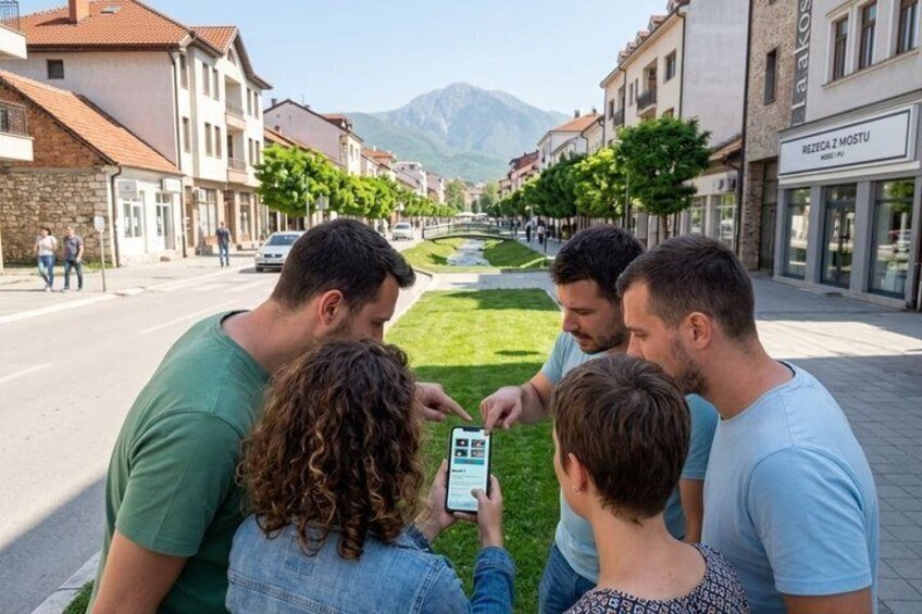 Un groupe de personnes utilisant un smartphone dans une rue de la ville, avec des bâtiments et une montagne en arrière-plan. 1