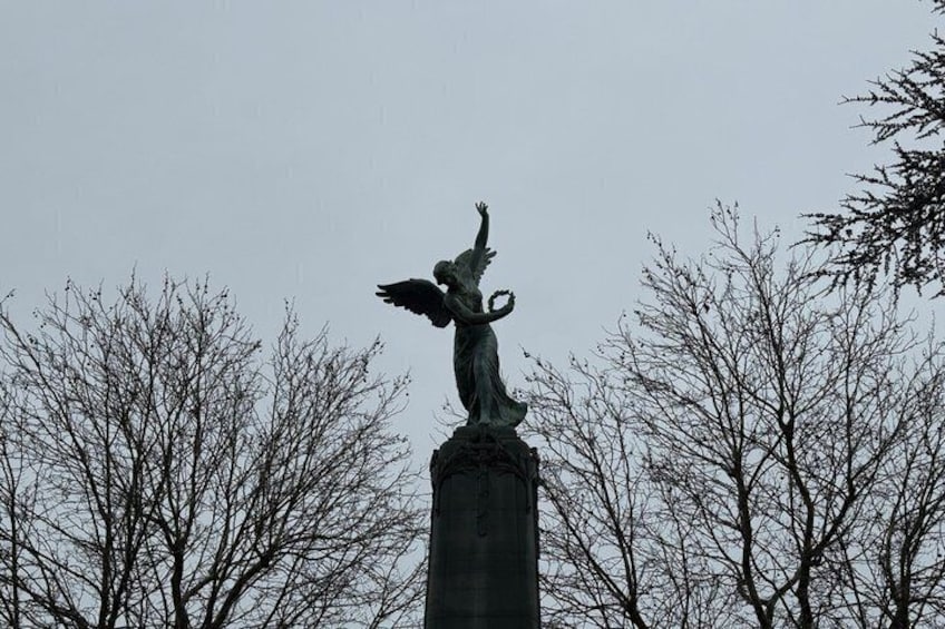 A statue of an angel with outstretched wings on a column. 1