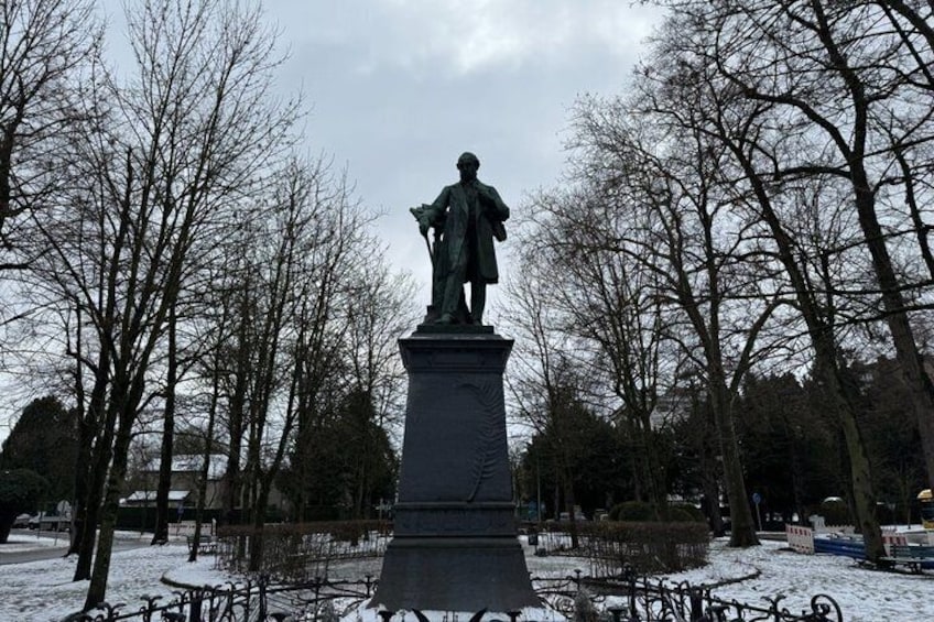 A statue in a park with bare trees and snow on the ground. 3