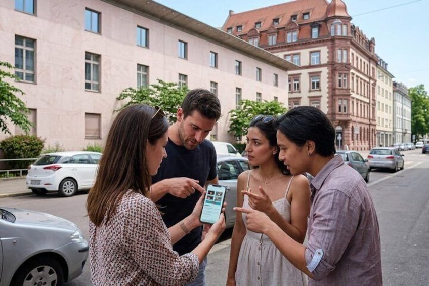Four people standing on a street, one holding a smartphone. 2