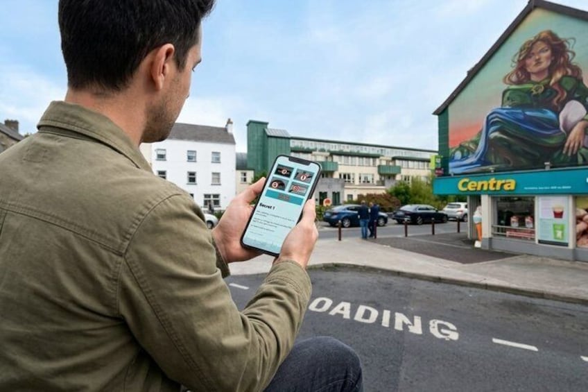 A person using a smartphone, a Centra store, and a road with 'ROADING' painted on it. 5