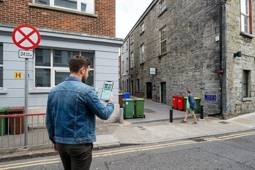 A man in a denim jacket holding a tablet, a no parking sign, and a 24-hour access sign. 2