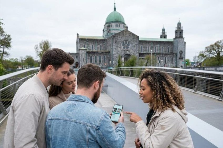 A group of people on a bridge with a historic building in the background. 4