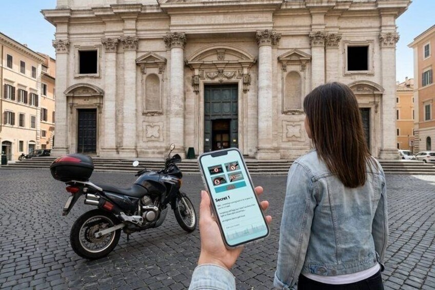 Eine Person hält ein Smartphone mit einer Karten-App, im Hintergrund ein Motorrad und ein historisches Gebäude. 2