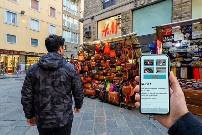 En person går forbi et gade marked, mens en smartphone viser en besked. 4