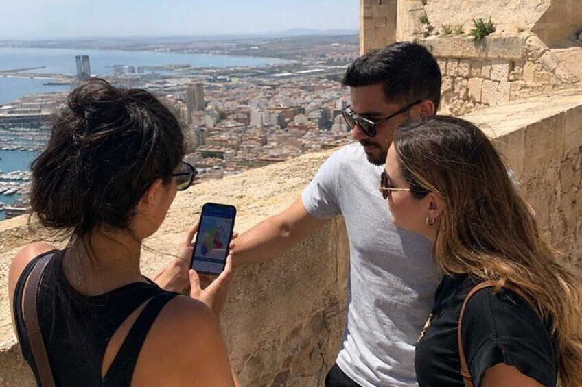 Tres personas fotografiando un paisaje urbano desde un lugar elevado. 3