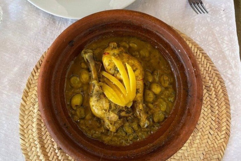 A clay pot with a stew, placed on a woven mat. 2