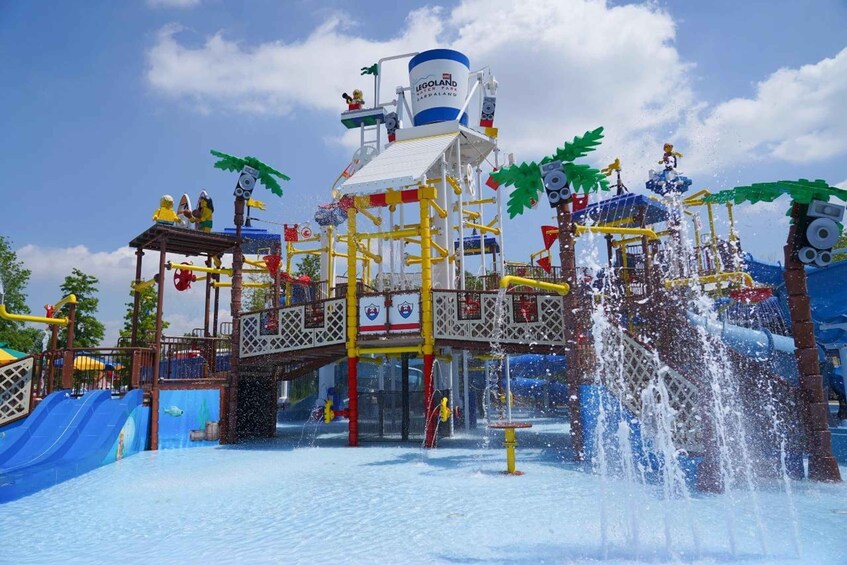 A water park with a water slide, splash pad, and a LEGO-themed structure. 5