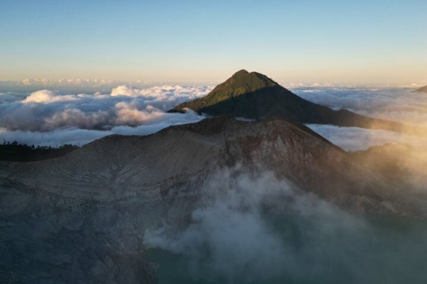 A mountain with a snow-capped peak, surrounded by clouds and mist. 5