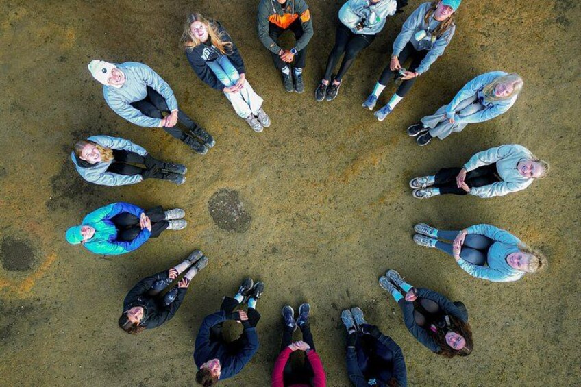 A group of people standing in a circle on a concrete surface. 2