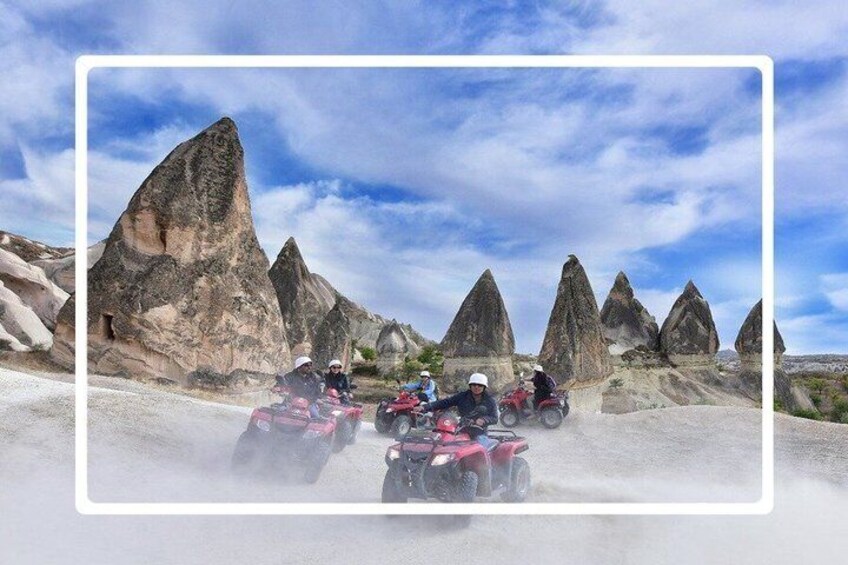 Four people on quad bikes in a rocky terrain with prominent rock formations. 1