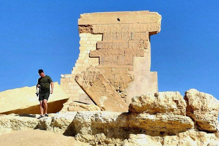 A man standing near ancient Egyptian ruins with hieroglyphs. 2