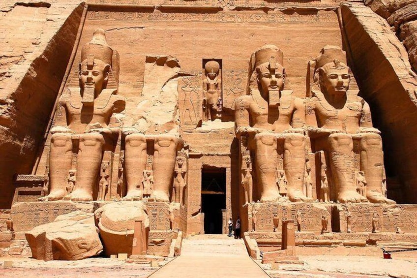 A large ancient Egyptian temple with colossal statues of pharaohs and hieroglyphics. 1