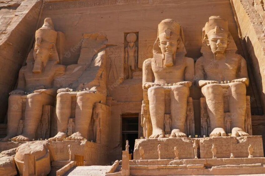 A large stone structure with seated figures and a doorway. 5