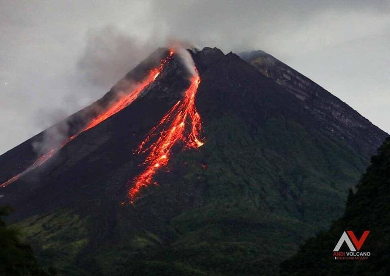 A volcano with lava flowing down its side. 2