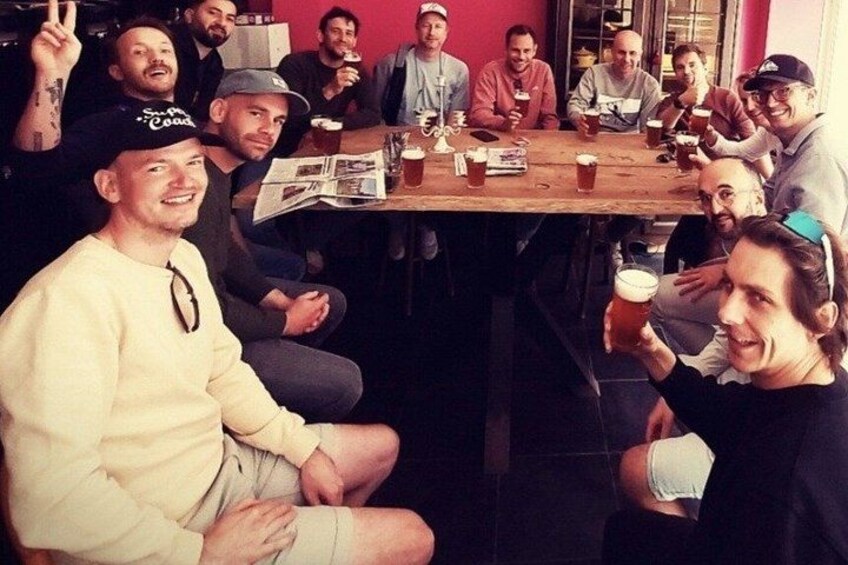 Un grupo de personas sentadas alrededor de una mesa de madera en un ambiente relajado. 5