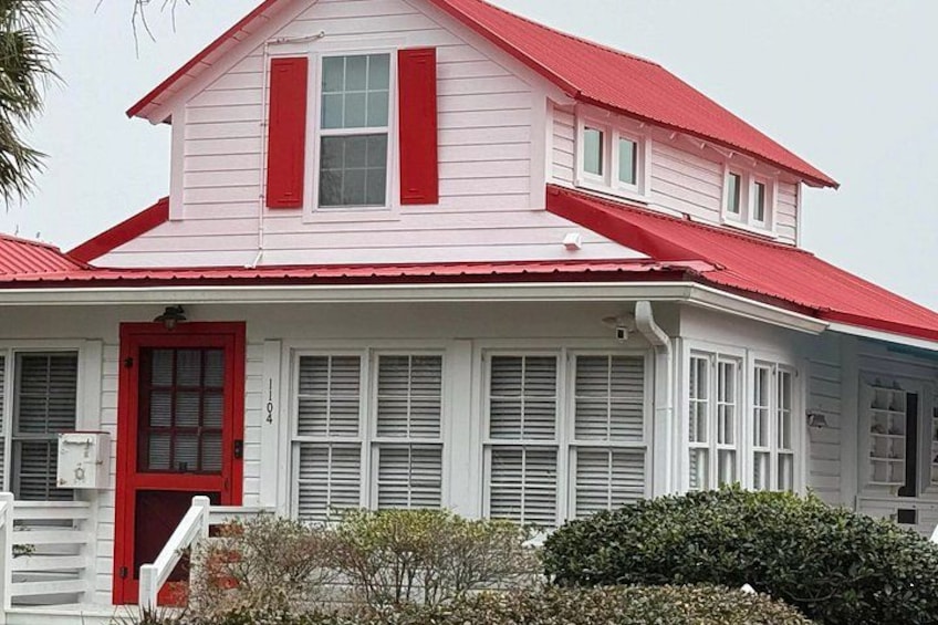 A two-story house with a red roof and white siding. 4