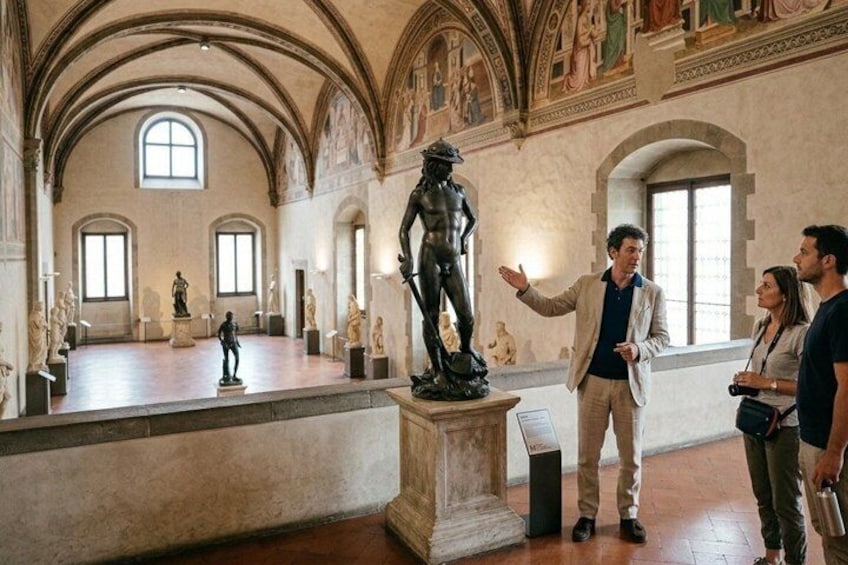 A museum interior with classical statues, arched ceilings, and a central sculpture. 4