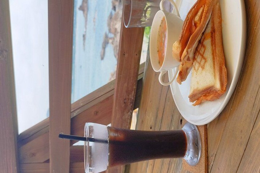 A table with a plate of food, a cup of coffee, and a glass of iced tea. 2