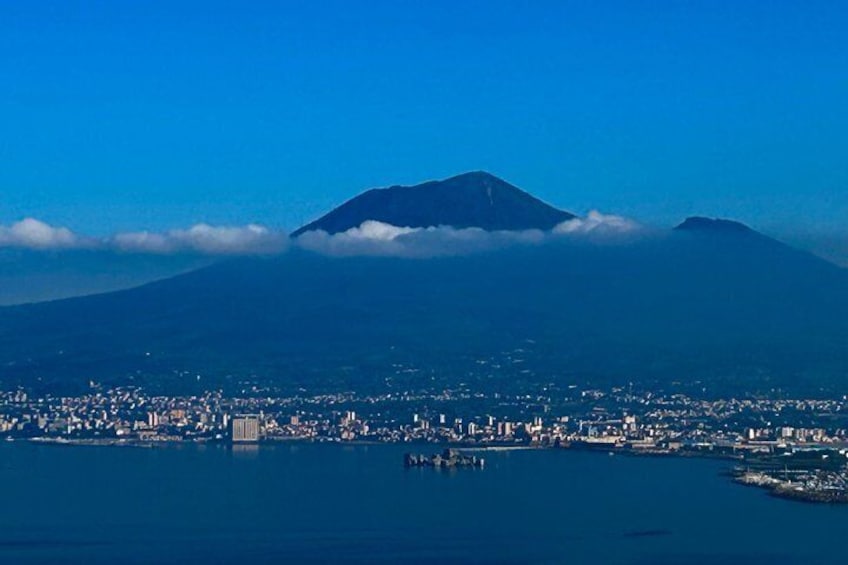 A coastal city with a prominent mountain in the background. 1