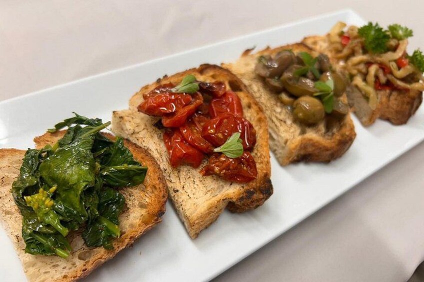 A white rectangular plate with four slices of toasted bread topped with different ingredients. 4