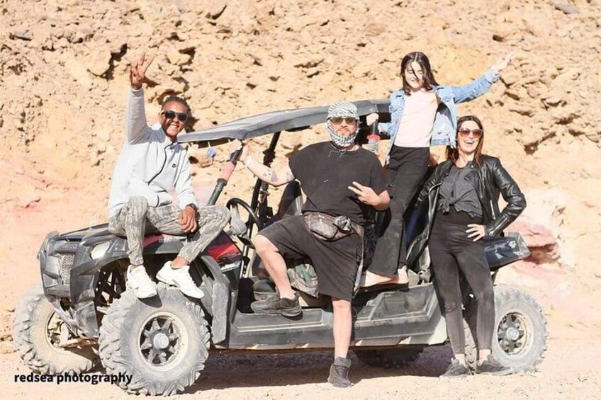 A group of people on a quad bike in a desert landscape. 2