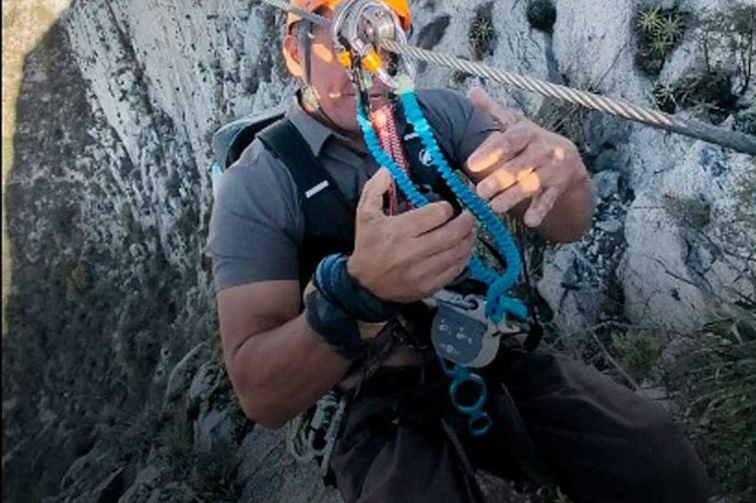 A person rappelling down a rocky cliff. 5