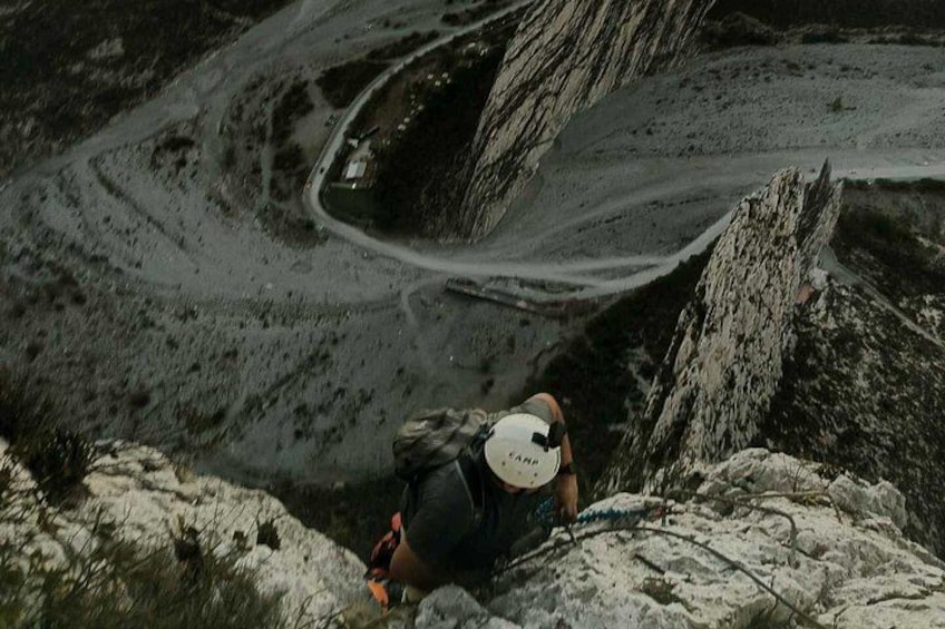 A hiker on a rocky mountain path with a backpack and a cap. 2
