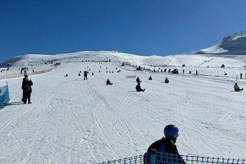 A snowy ski slope with skiers and snowboarders. 3