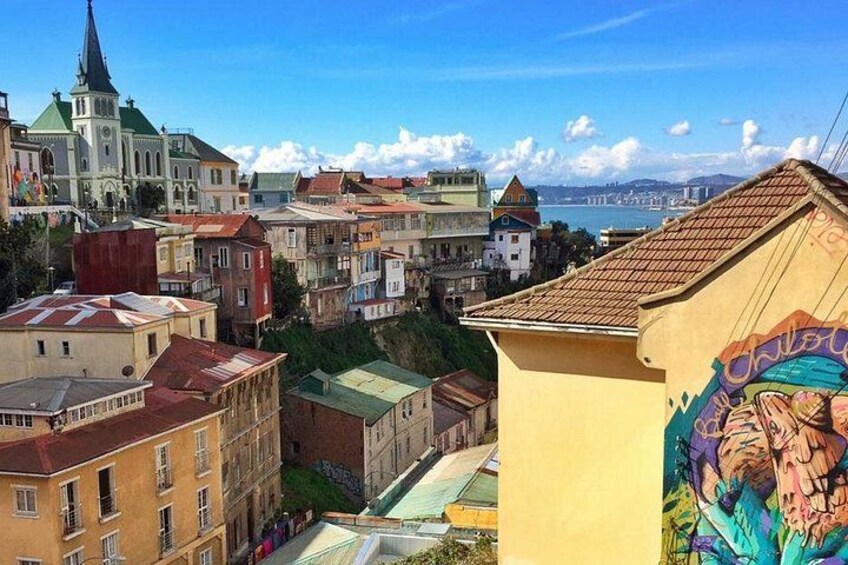 A cityscape with historic buildings, a church, and a mural on a building. 4