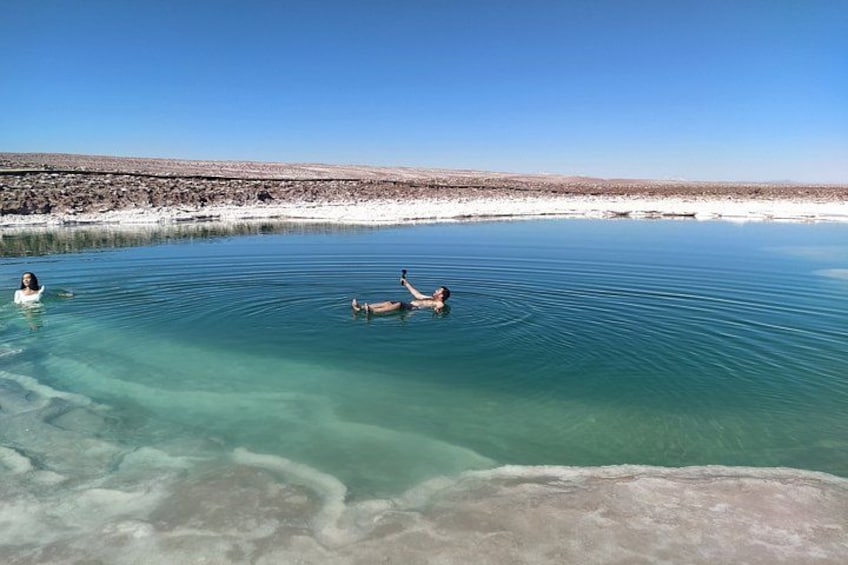 A clear lake with two people swimming. 2