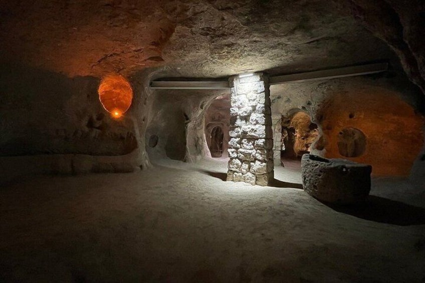 Una cueva subterránea con estalactitas, una pared de piedra y una abertura circular. 5