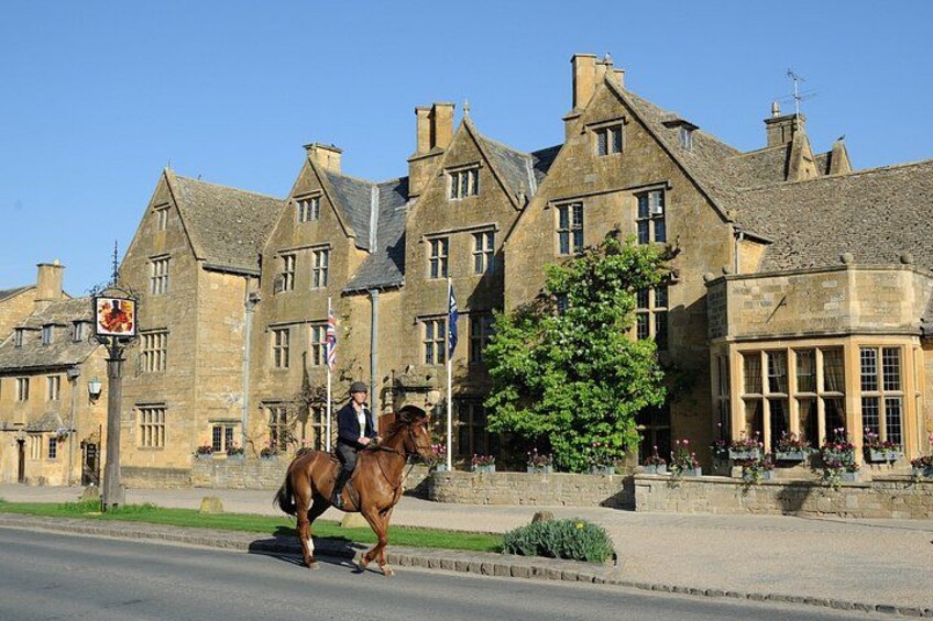A horse and rider on a street, historic buildings, and a clear blue sky. 2