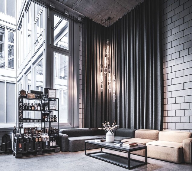 Een modern interieur met een bakstenen muur, grote ramen, een bank, een salontafel en een drankenkast. 2