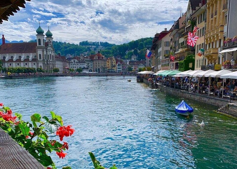 A river with a boat, buildings, and a bridge. 2