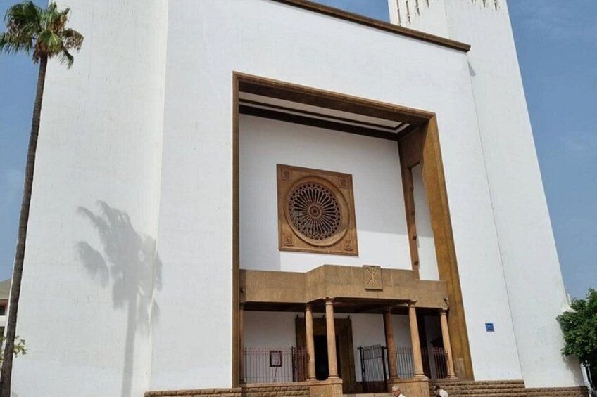A white building with a large circular window and a balcony. 3