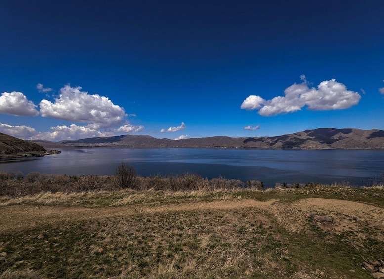 A lake surrounded by hills and a clear blue sky. 5