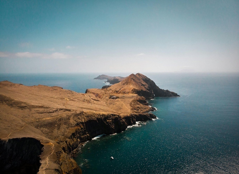 A rugged coastline with rocky cliffs and a clear blue sea. 4