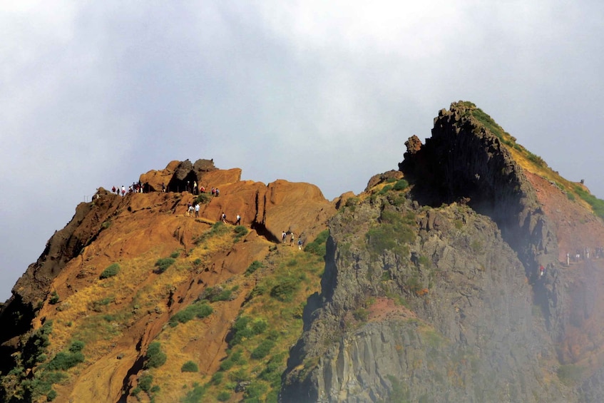 A rugged mountain landscape with hikers on the slopes. 3