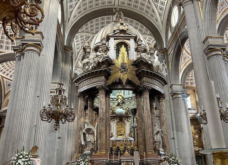 An ornate church interior with high ceilings, detailed sculptures, and a central altar. 5