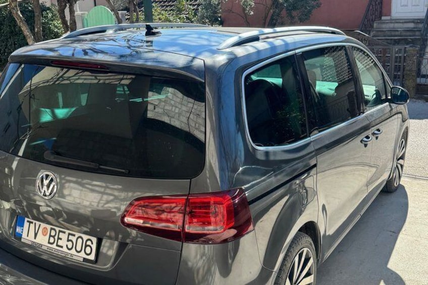 En grå Volkswagen-skåpbil stod parkerad på en gata. 2