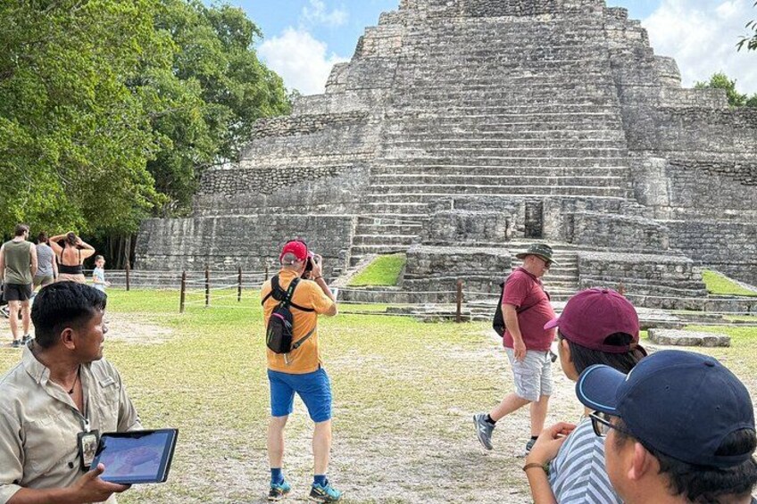 En stor, forntida stenstruktur, eventuellt en pyramid, med turister runt omkring. 2