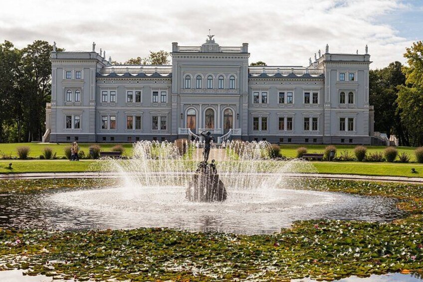 Un edificio grande y majestuoso con una fuente al frente. 4
