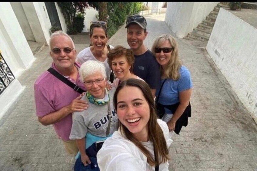 A group of people standing on a paved path with white walls on either side. 2