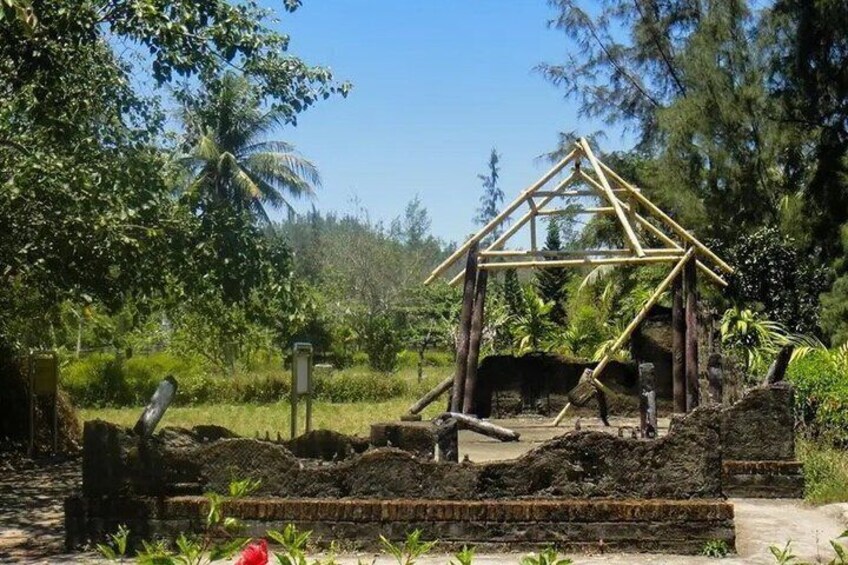 A wooden structure resembling a hut in a lush, green landscape with trees and a clear sky. 4