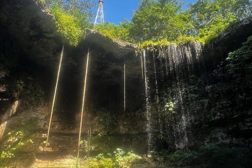 A waterfall cascading down a rocky cliff surrounded by greenery. 4