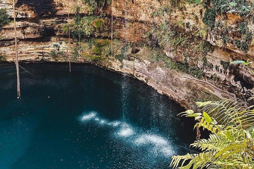 A natural pool surrounded by rocky cliffs and vegetation. 5